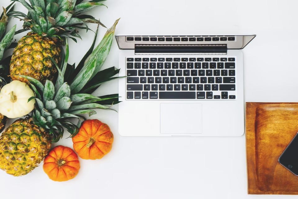 Laptop und Früchte auf einem Schreibtisch